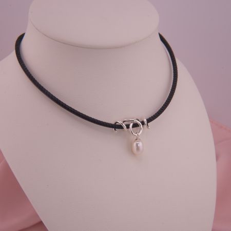Schwarze Lederkette Remolino mit gewickeltem 925 Sterling Silber Anhänger und einer frei schwingenden, weißen Süßwasserzuchtperle auf einer Schmuckbüste.